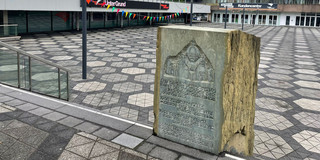 Ein Denkstein zur Erinnerung an eine jüdische Synagoge in einem Einkaufsviertel