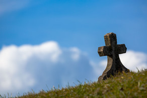 Steinernes Kreuz auf einer Wiese