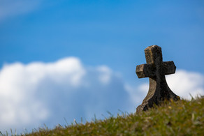 Steinernes Kreuz auf einer Wiese