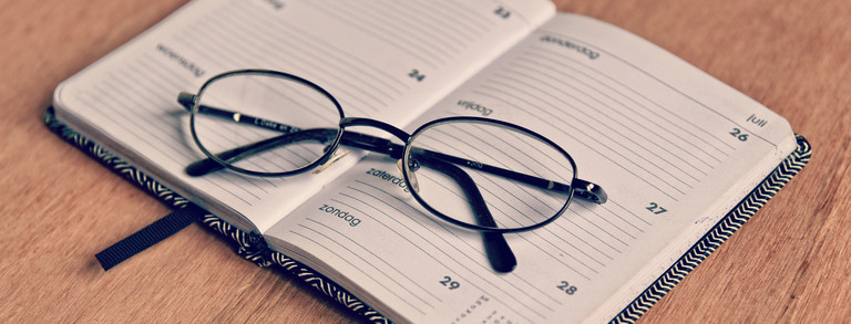 Offener Terminkalender auf dem eine Brille liegt